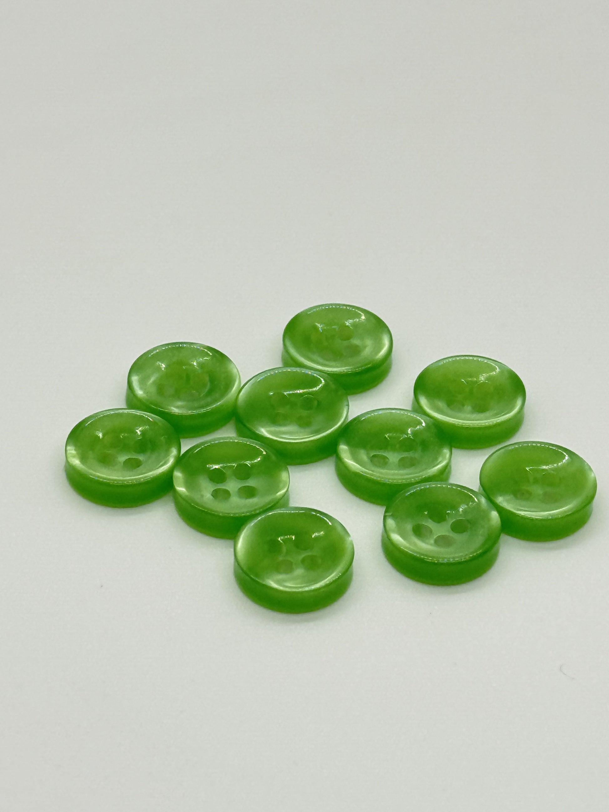 Close-up image of Green Iridescent 4-hole Button, a premium quality button.