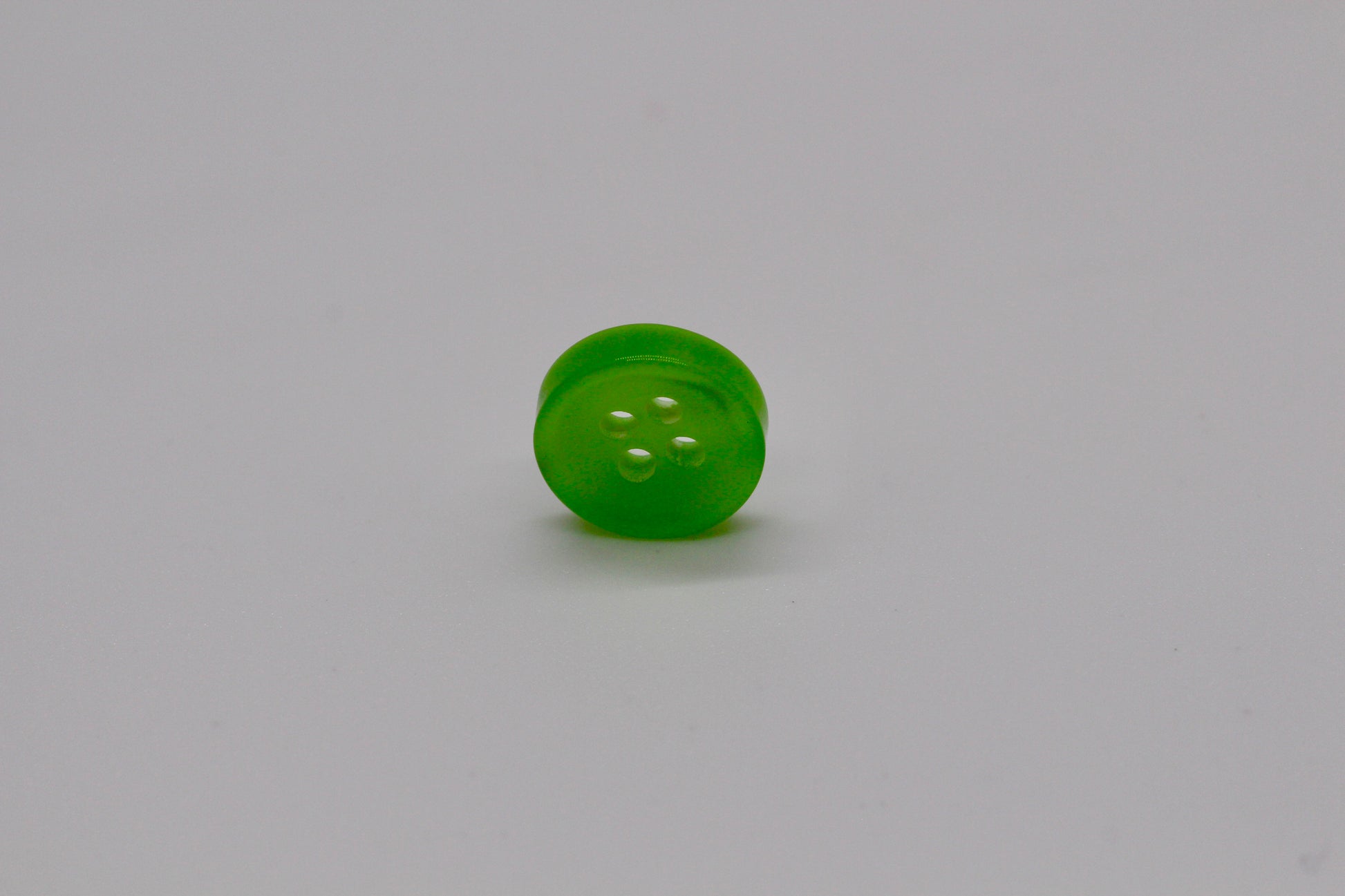 Close-up image of Green Iridescent 4-hole Button, a premium quality button.