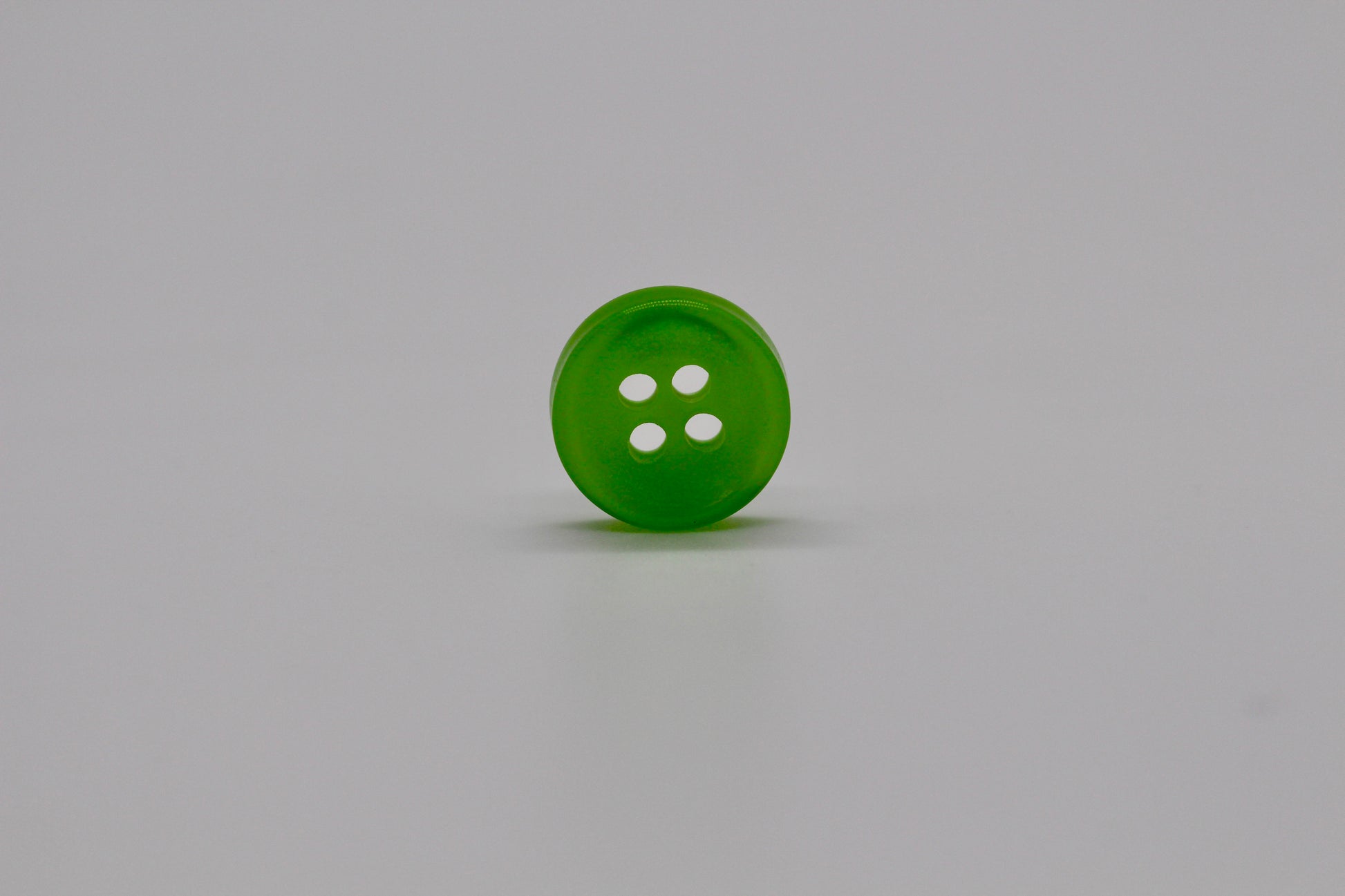 Close-up image of Green Iridescent 4-hole Button, a premium quality button.