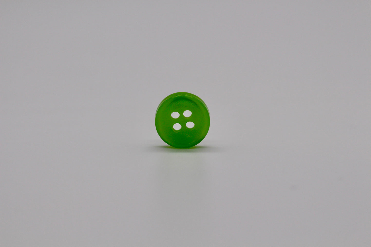 Close-up image of Green Iridescent 4-hole Button, a premium quality button.