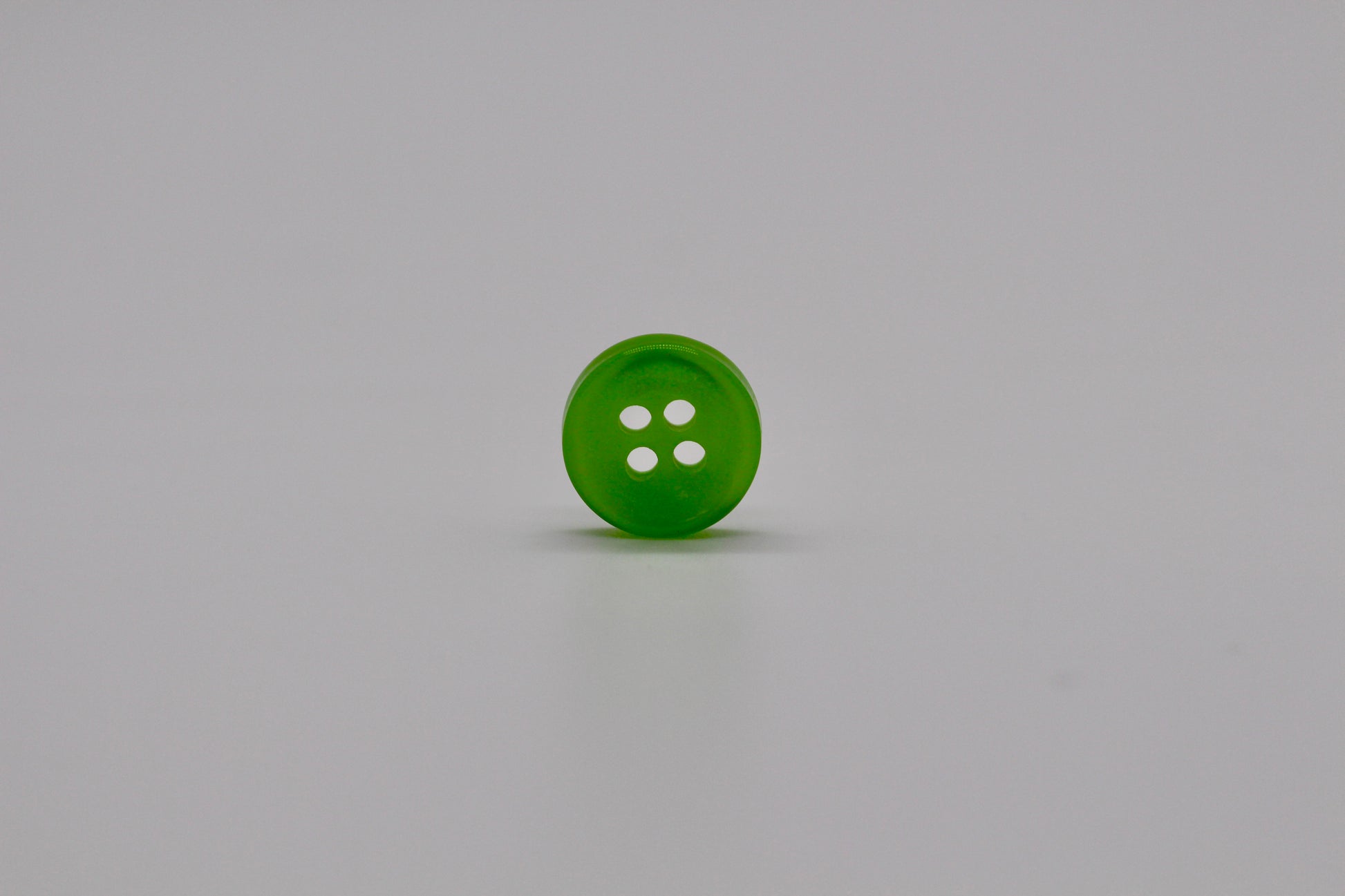 Close-up image of Green Iridescent 4-hole Button, a premium quality button.