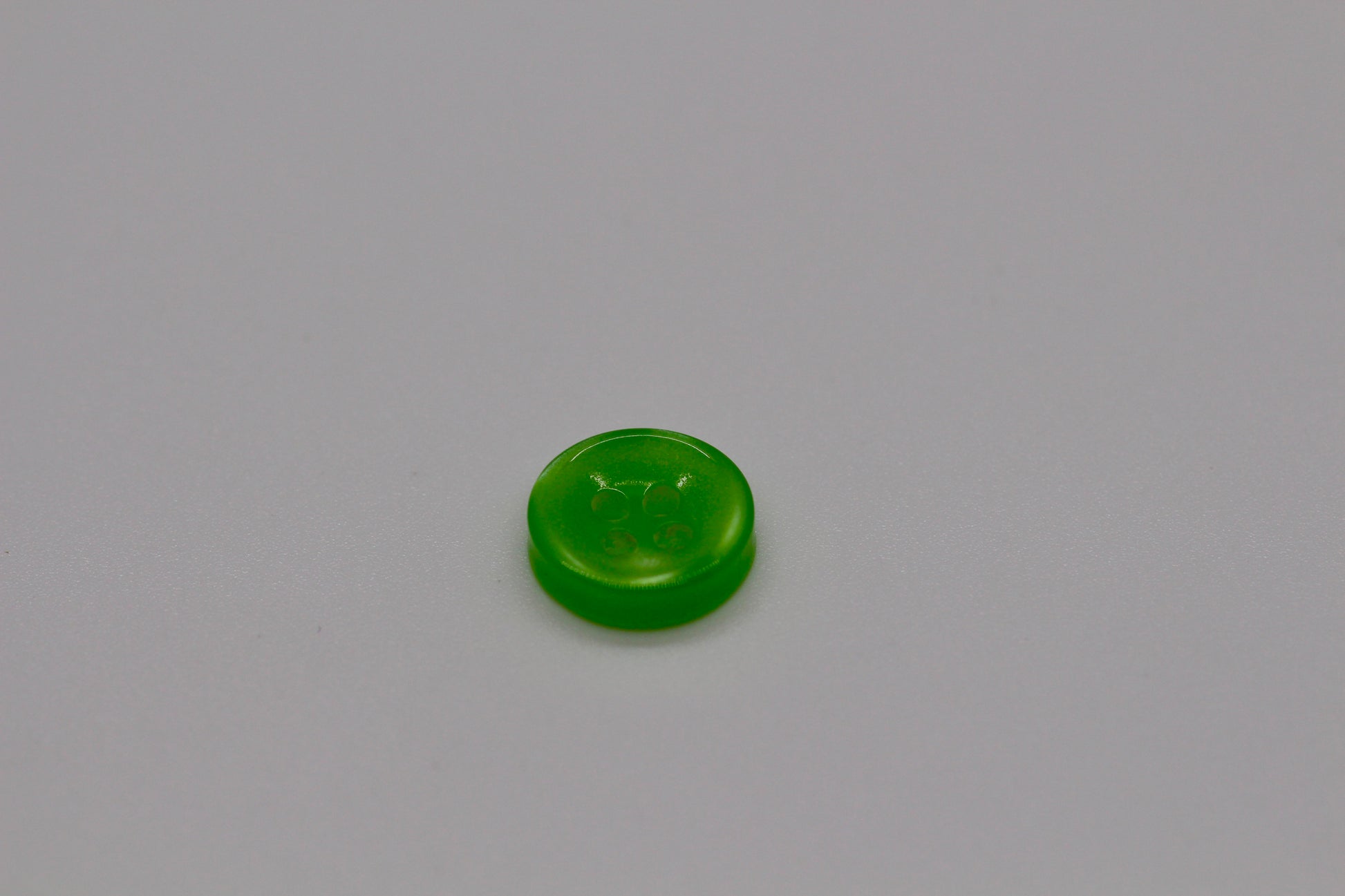 Close-up image of Green Iridescent 4-hole Button, a premium quality button.