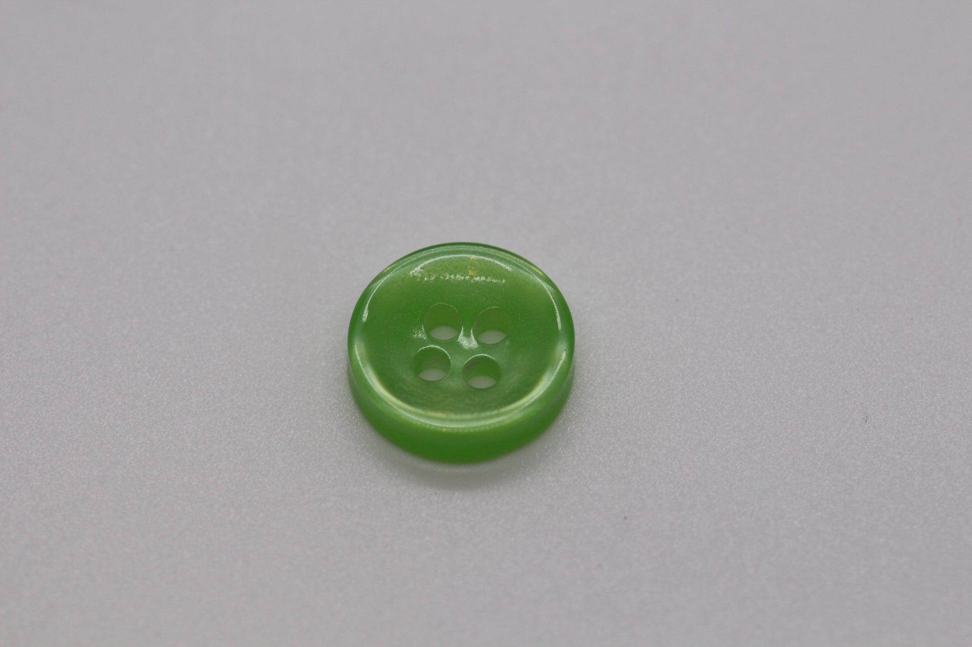 Close-up image of Green Iridescent 4-hole Button, a premium quality button.