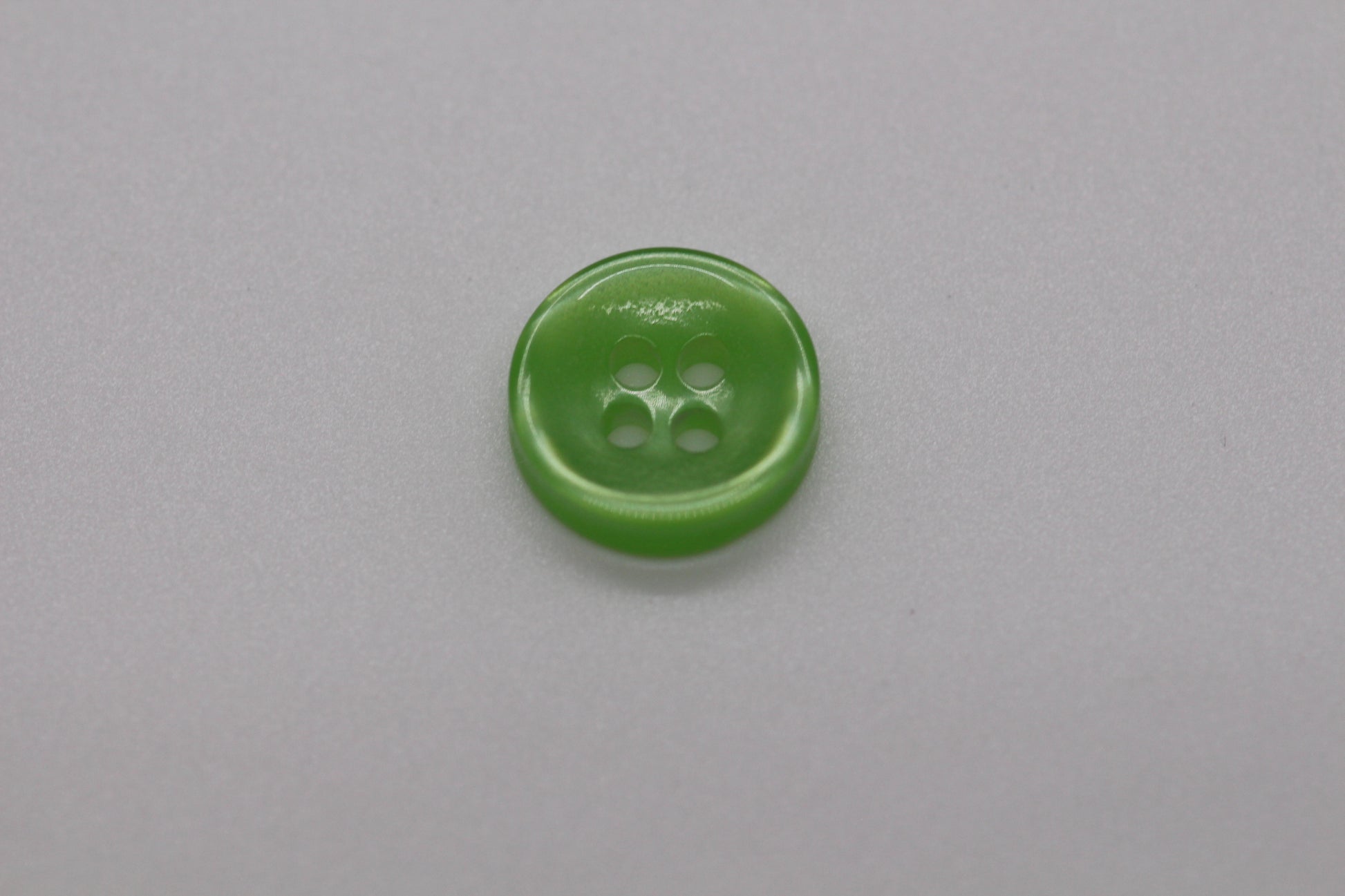 Close-up image of Green Iridescent 4-hole Button, a premium quality button.