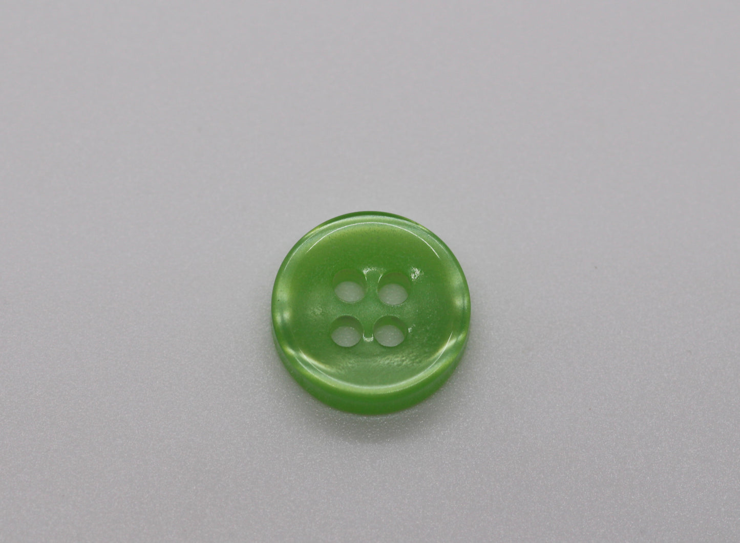 Close-up image of Green Iridescent 4-hole Button, a premium quality button.