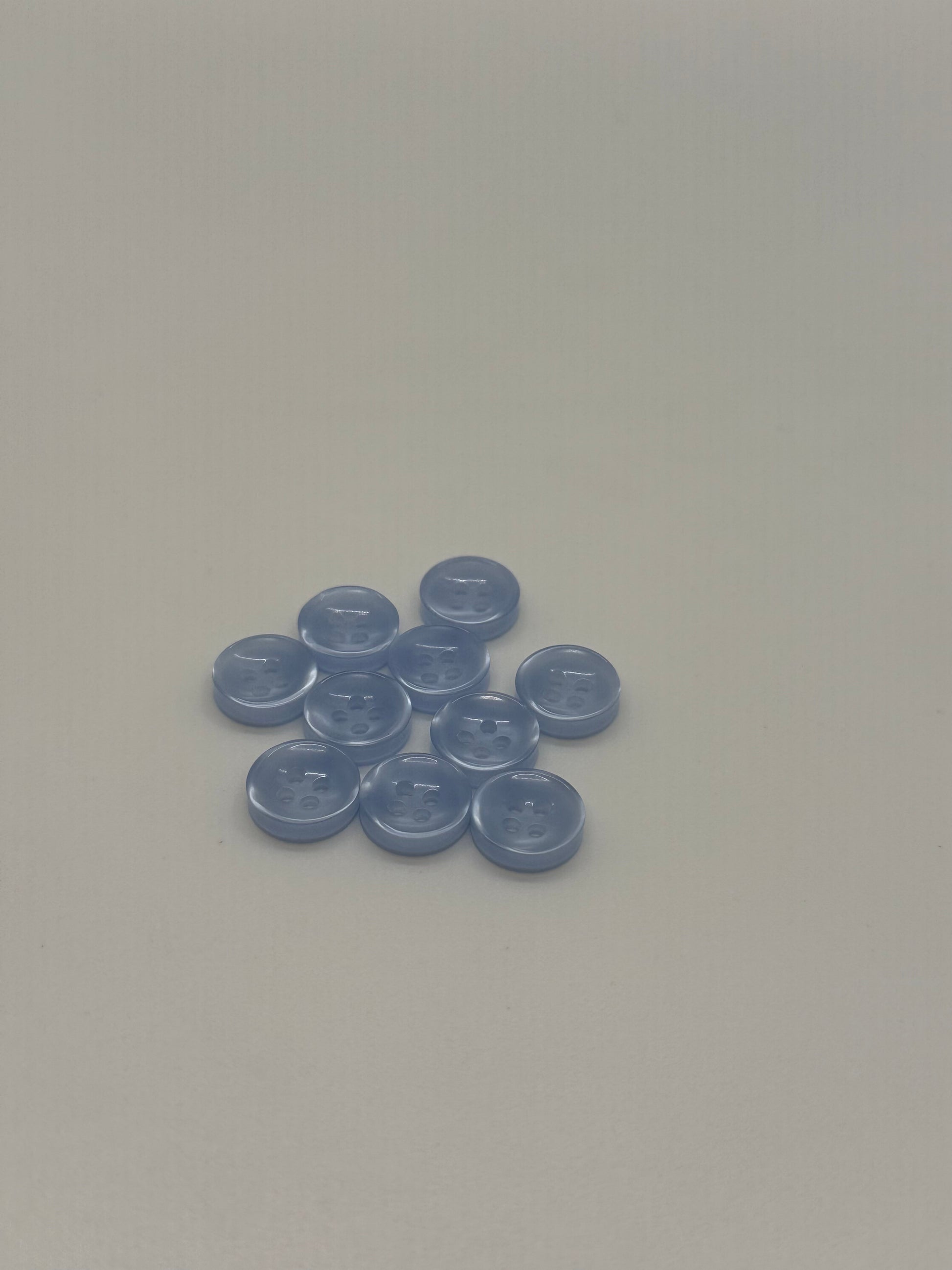 Close-up image of Crystal Tide - Light Blue Iridescent 18-Ligne Button, a premium quality button.