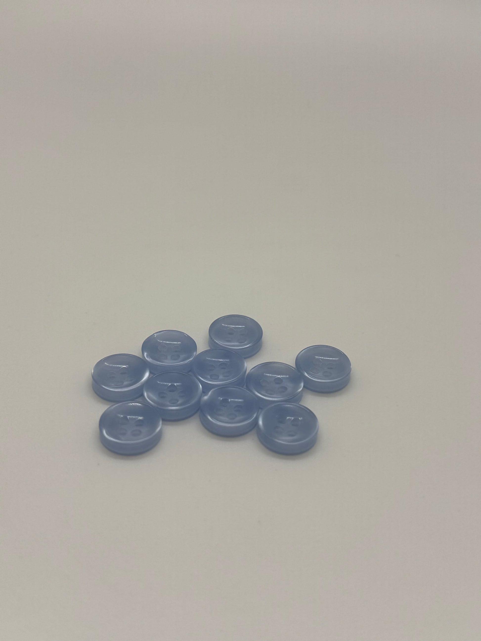 Close-up image of Crystal Tide - Light Blue Iridescent 18-Ligne Button, a premium quality button.