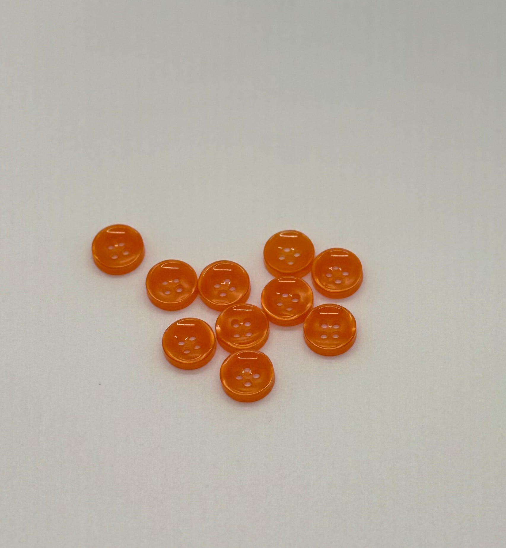 Close-up image of Ember Glow - Orange Iridescent 18-Ligne Button, a premium quality button.