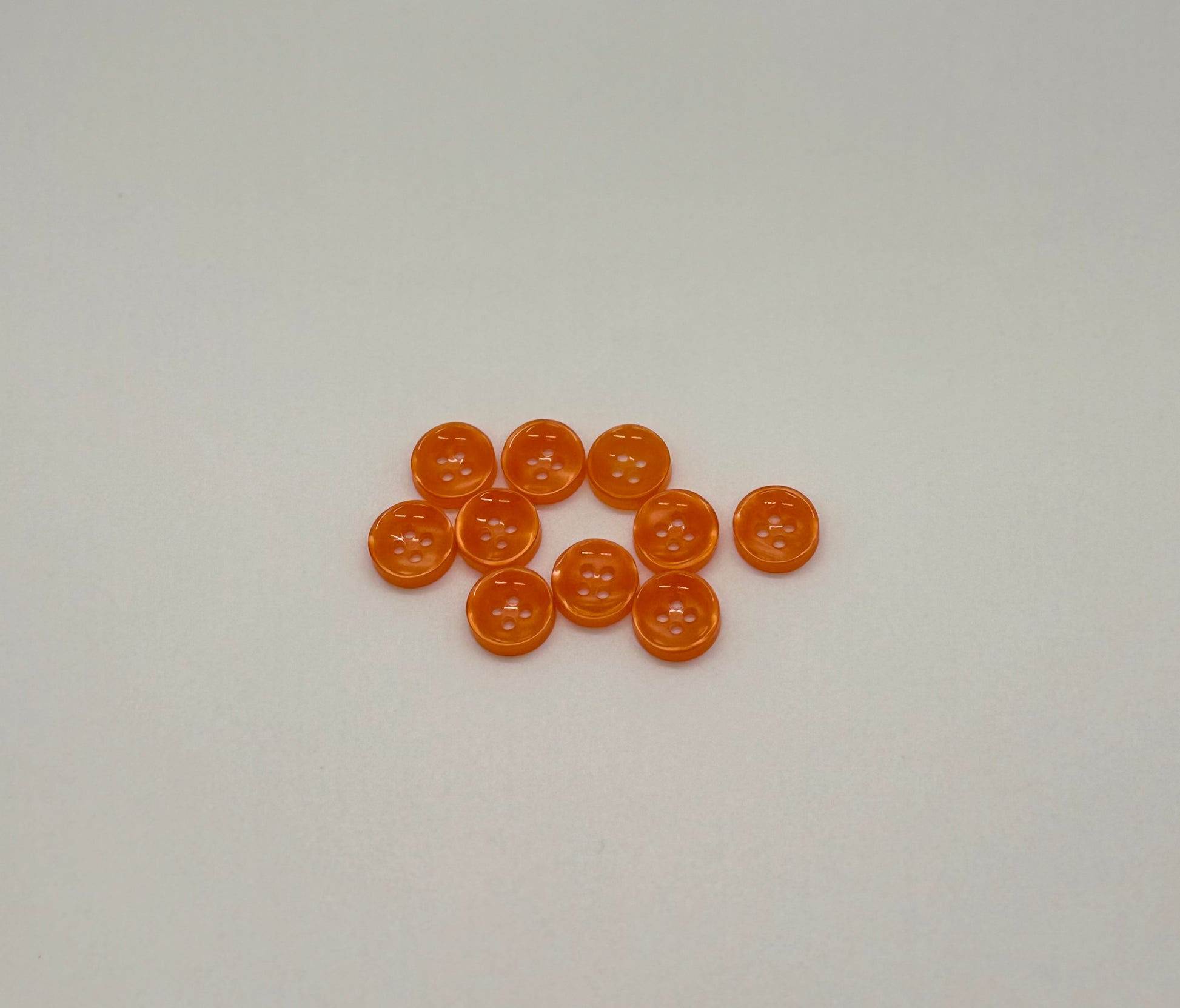 Close-up image of Ember Glow - Orange Iridescent 18-Ligne Button, a premium quality button.