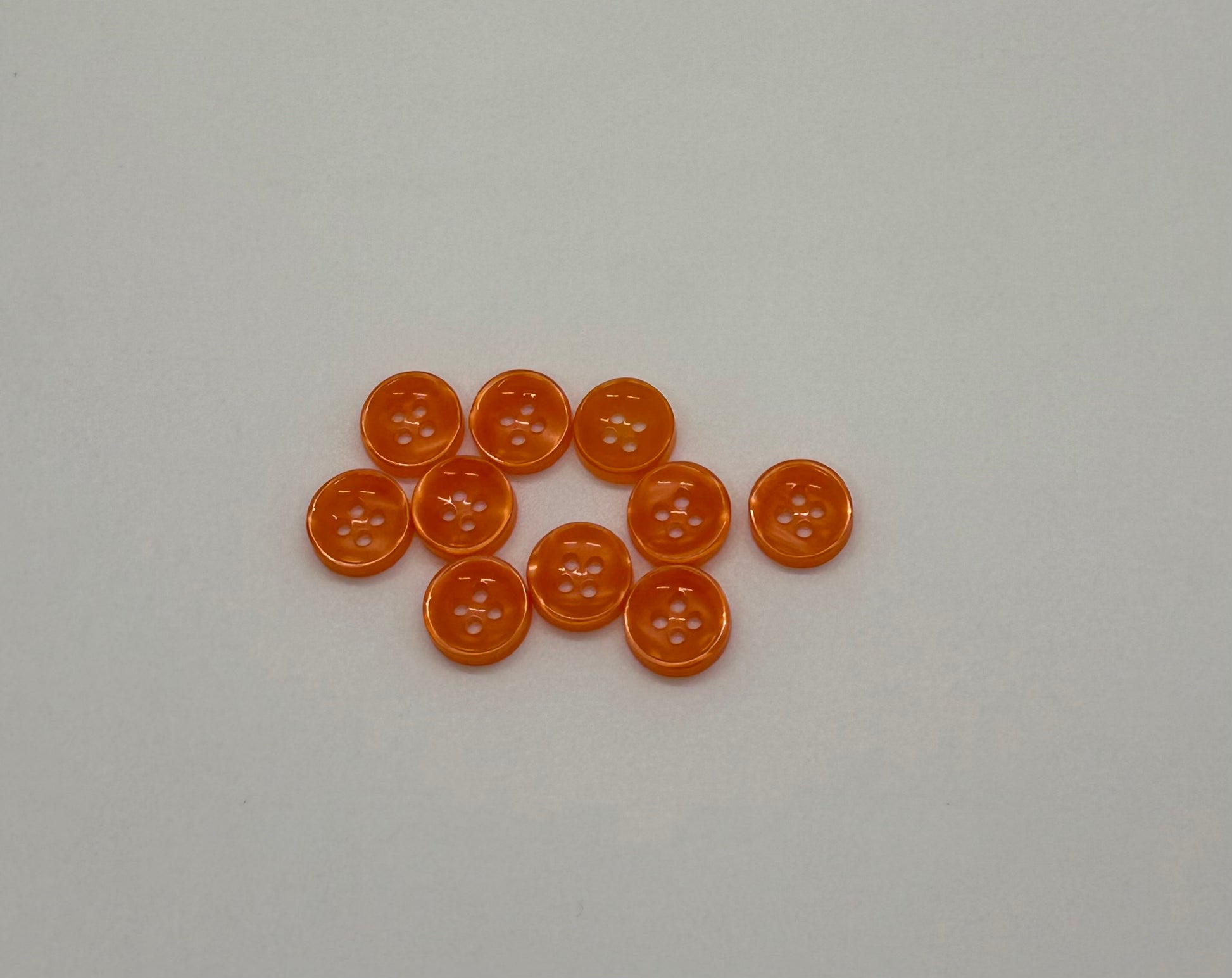Close-up image of Ember Glow - Orange Iridescent 18-Ligne Button, a premium quality button.