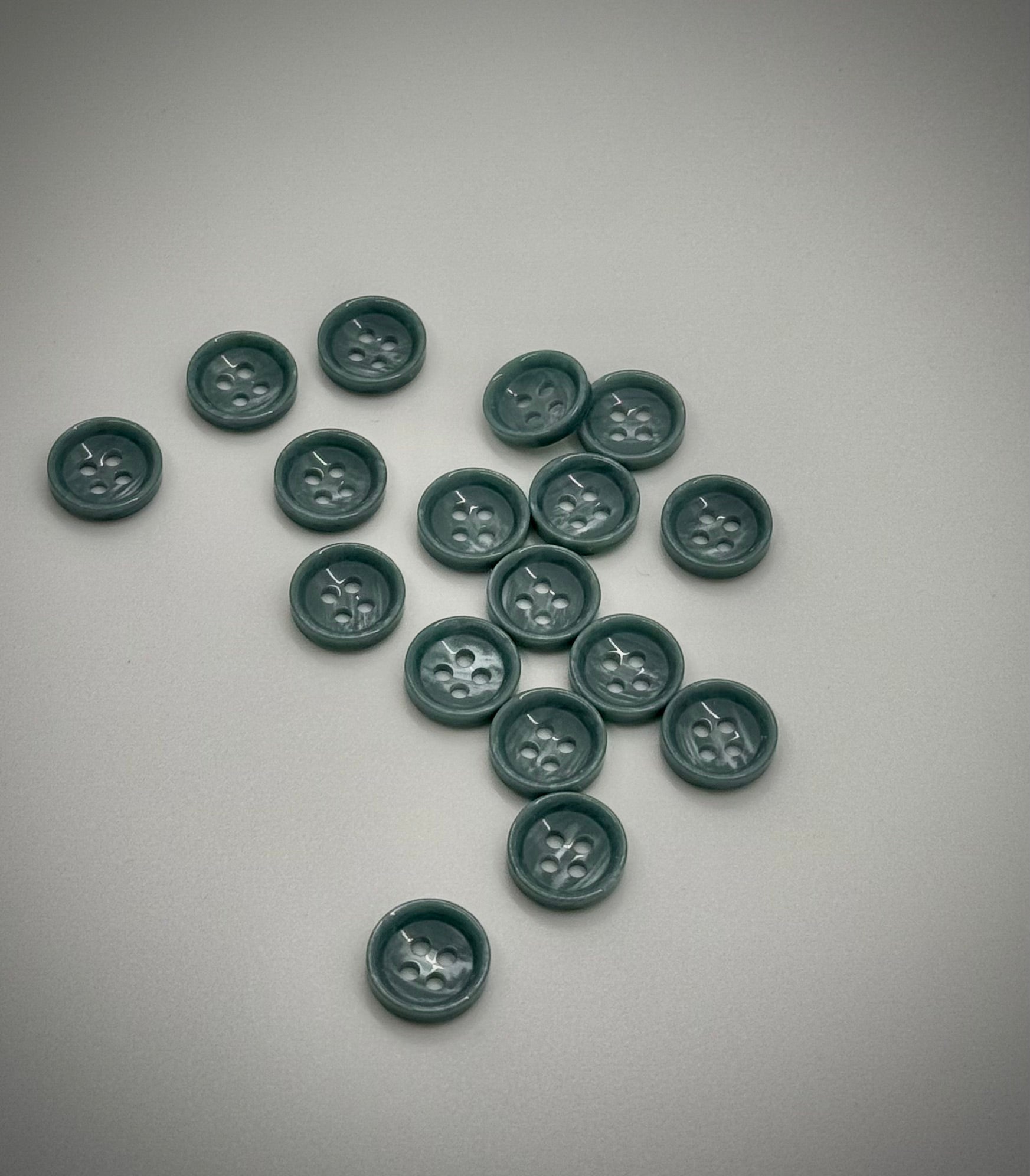 Close-up image of Jade Ridge Dimple 18L Button, a premium quality button.