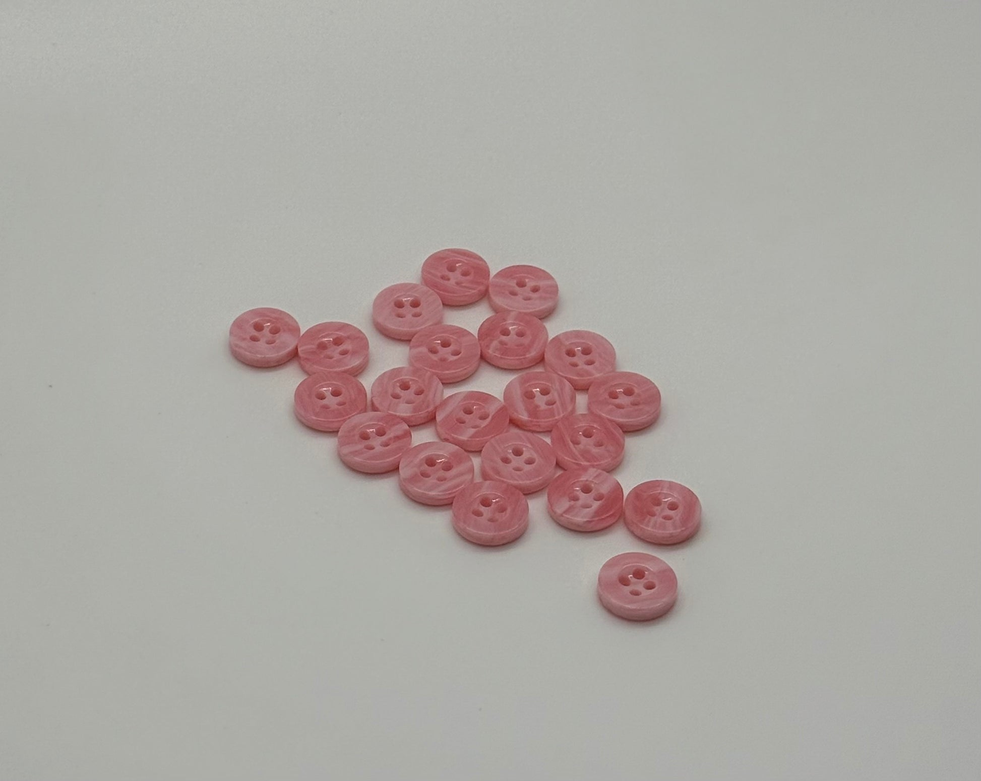 Close-up image of Pink Cloud 4-Hole 18L Button, a premium quality button.
