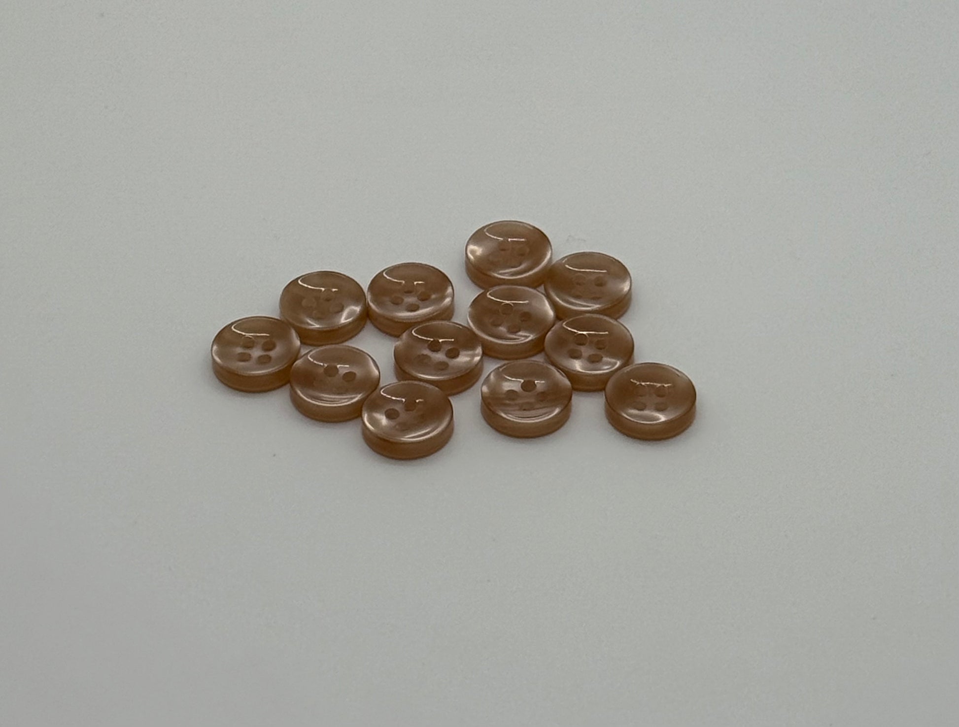 Close-up image of Warm Sand - Light Brown Iridescent 18-Ligne Button, a premium quality button.
