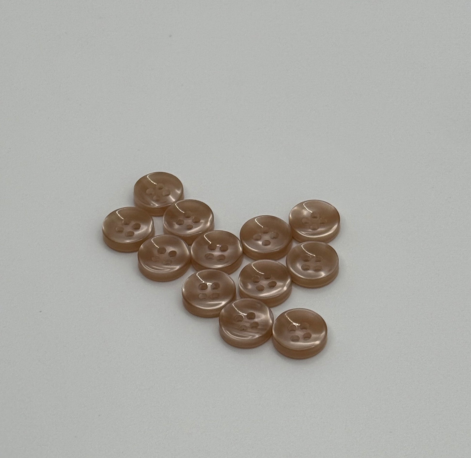 Close-up image of Warm Sand - Light Brown Iridescent 18-Ligne Button, a premium quality button.