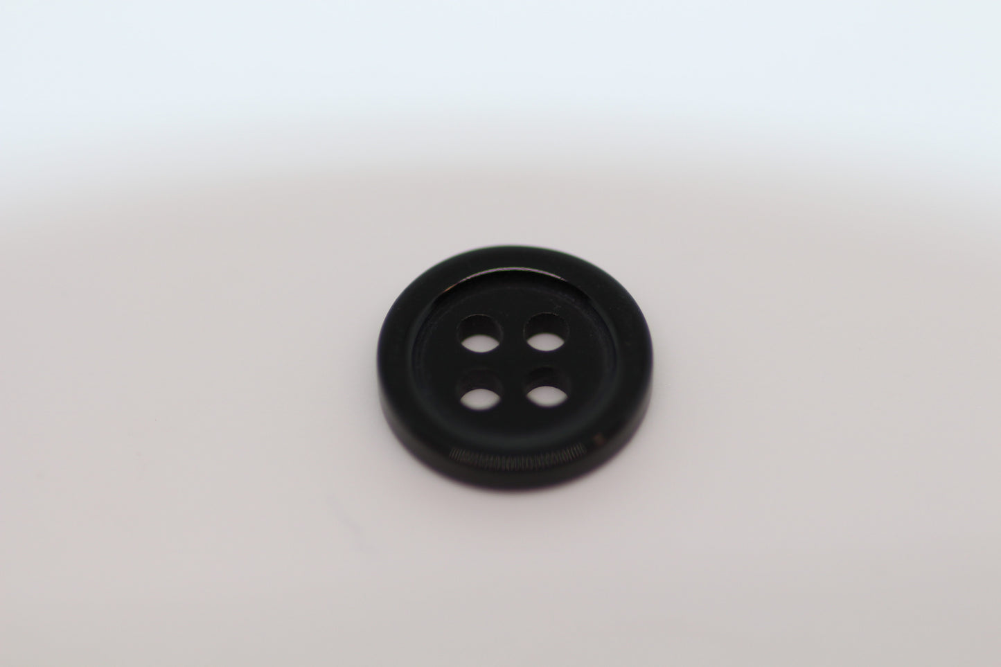 Close-up image of Black Pie Crust Polymer Button, a premium quality button.