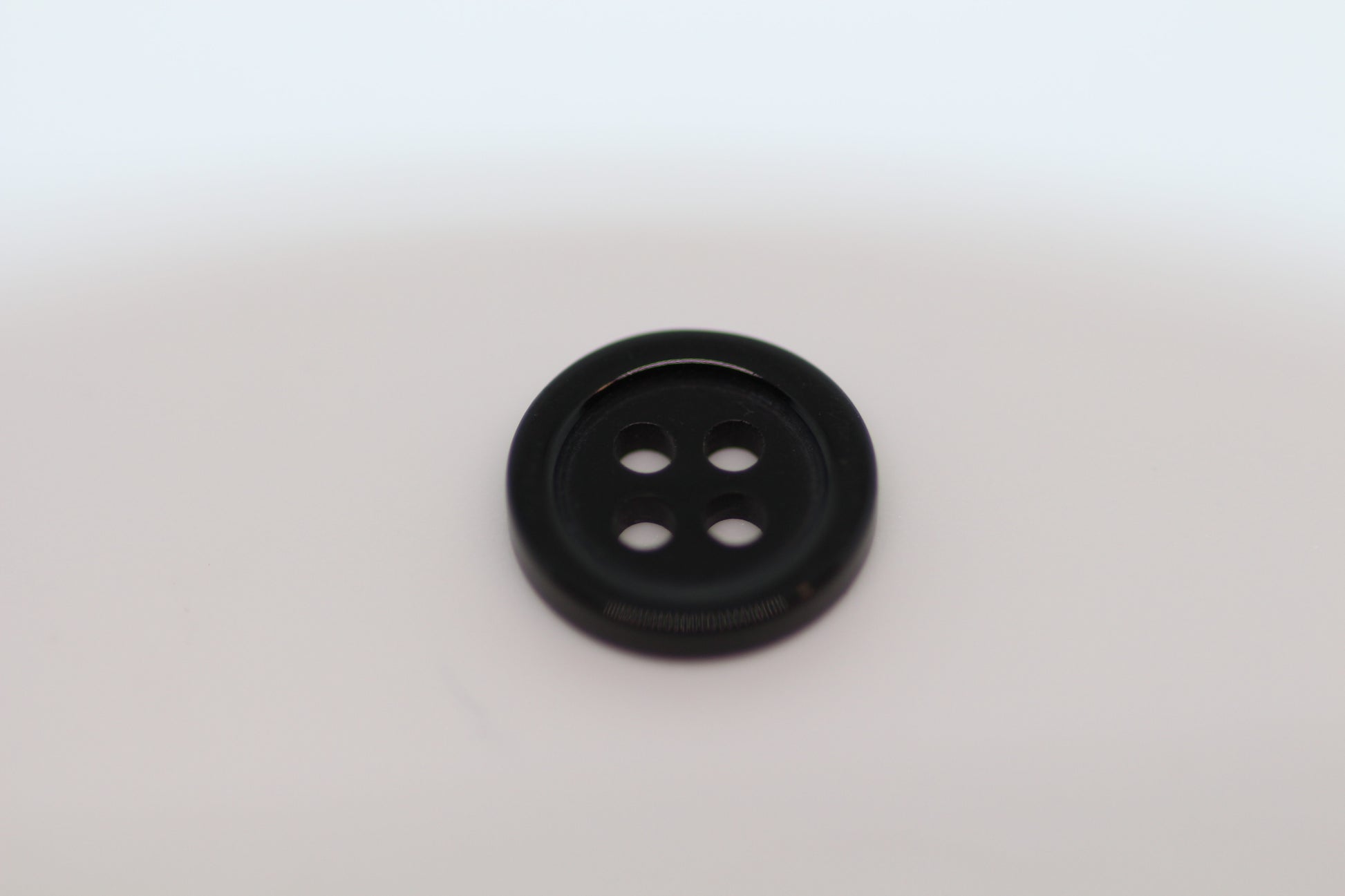 Close-up image of Black Pie Crust Polymer Button, a premium quality button.