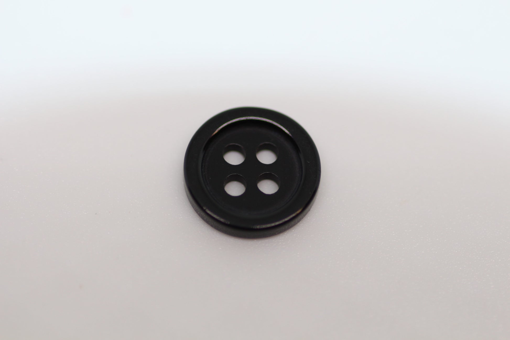 Close-up image of Black Pie Crust Polymer Button, a premium quality button.