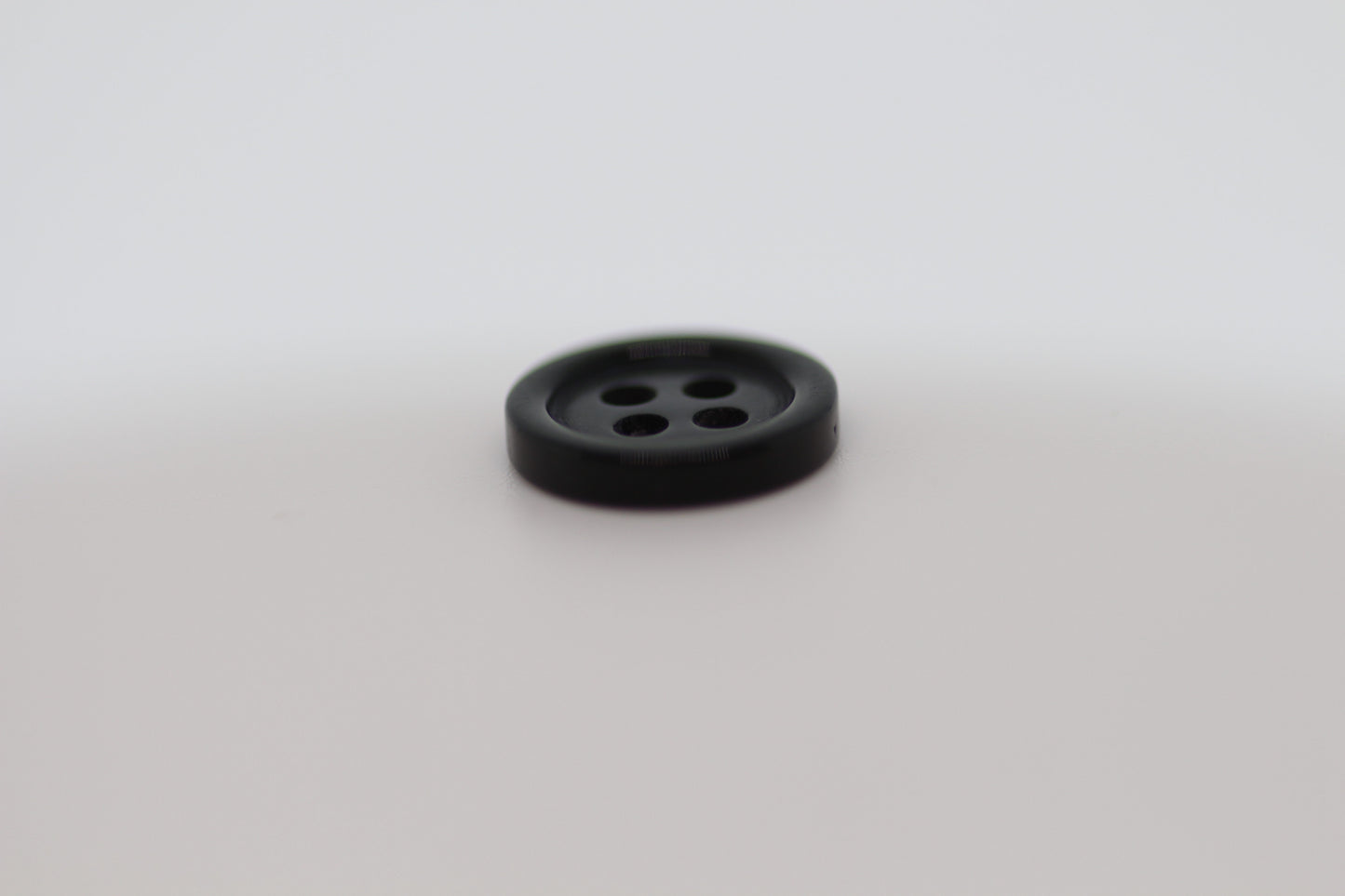 Close-up image of Black Pie Crust Polymer Button, a premium quality button.