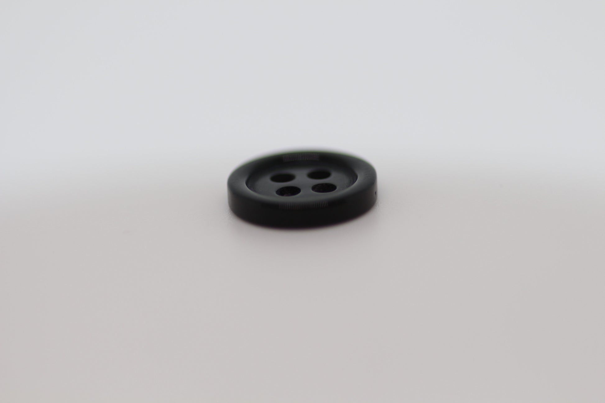 Close-up image of Black Pie Crust Polymer Button, a premium quality button.