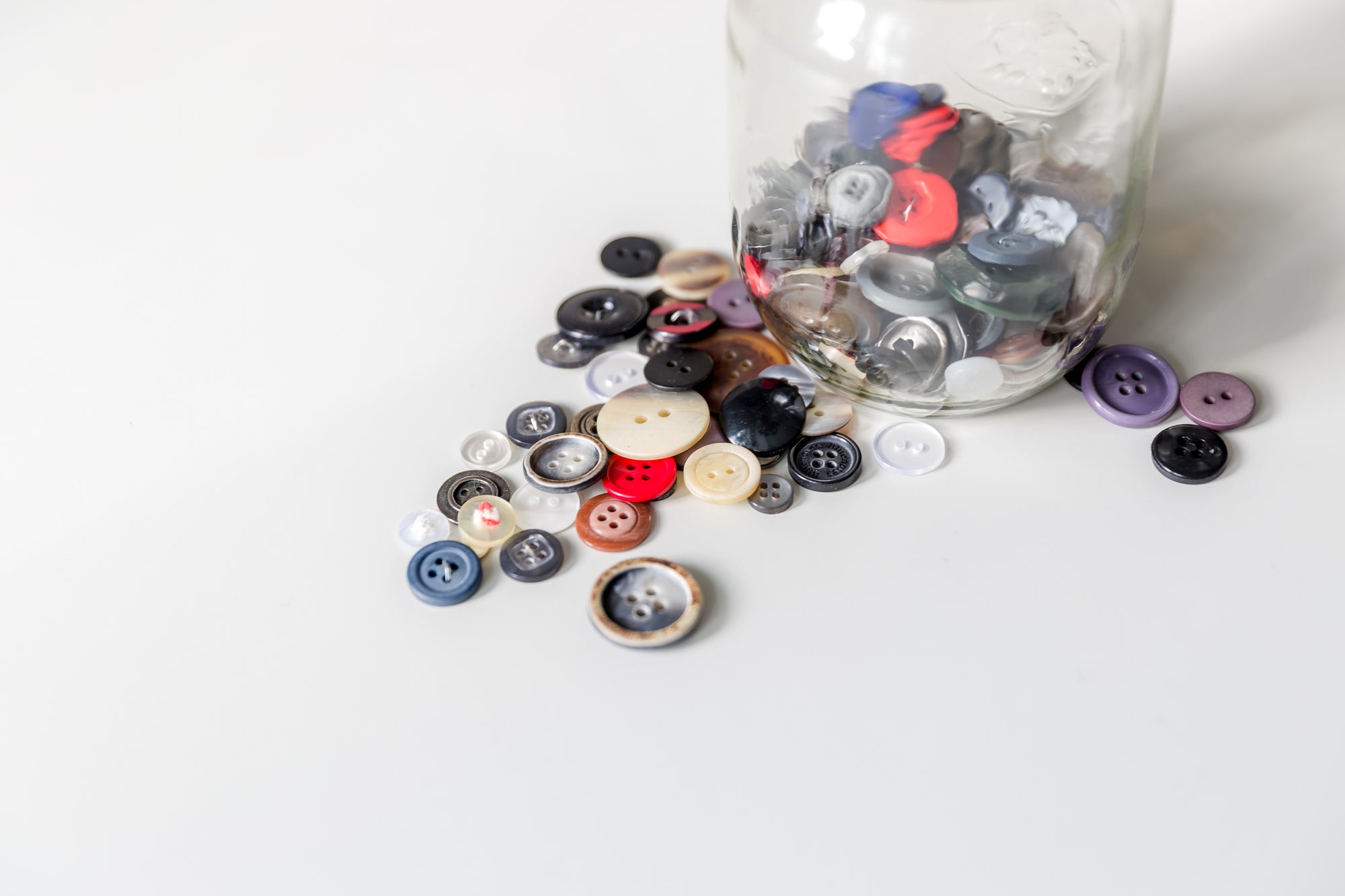 Assorted colorful buttons in a glass jar